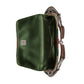 Green bag with brown leather strap on a light gray background