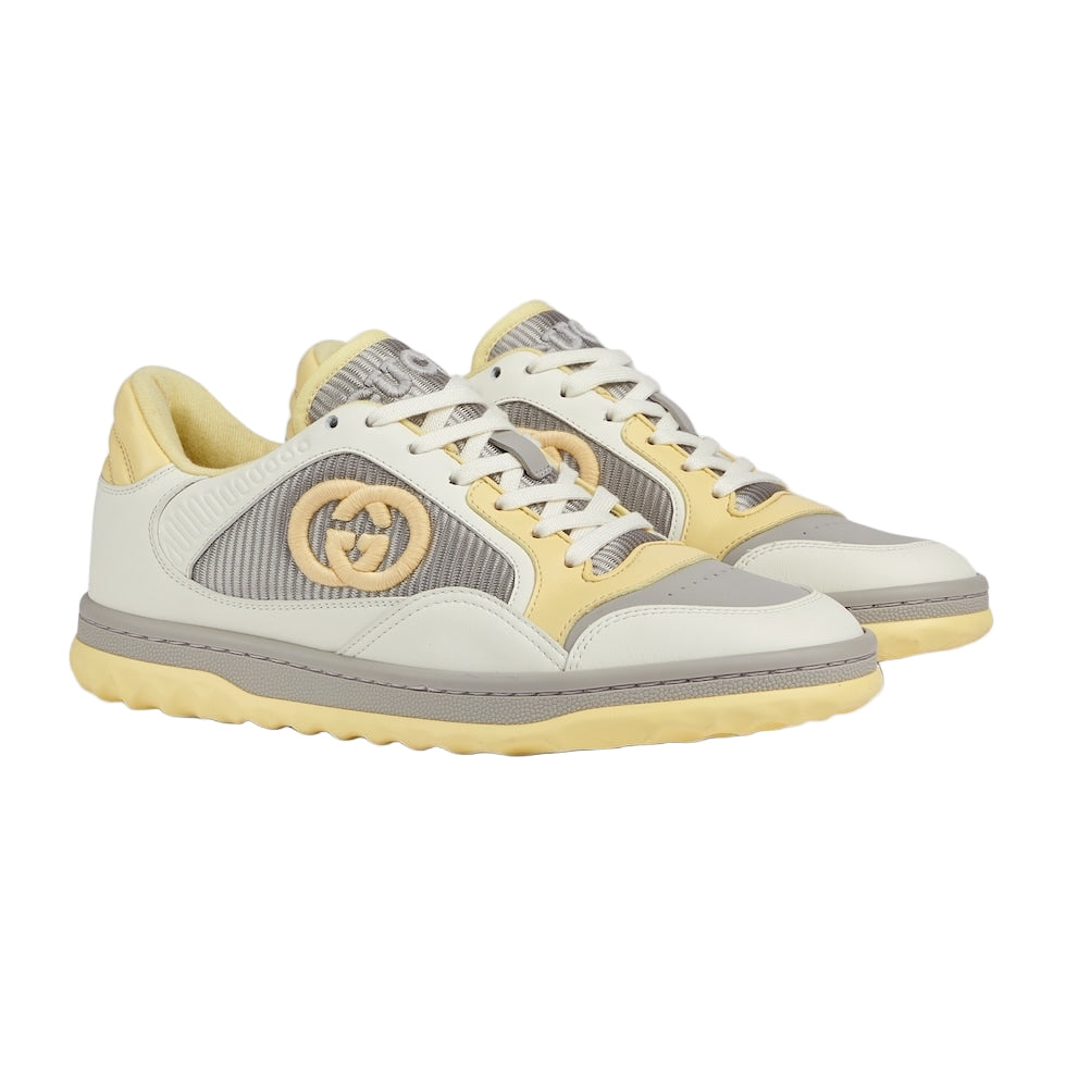 Pair of sneakers with a mix of gray, yellow, and white on a light gray background