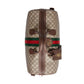 Gucci bag with monogram pattern and iconic green and red stripes on a light gray background