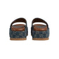 Pair of blue patterned sandals with brown soles on a light gray background