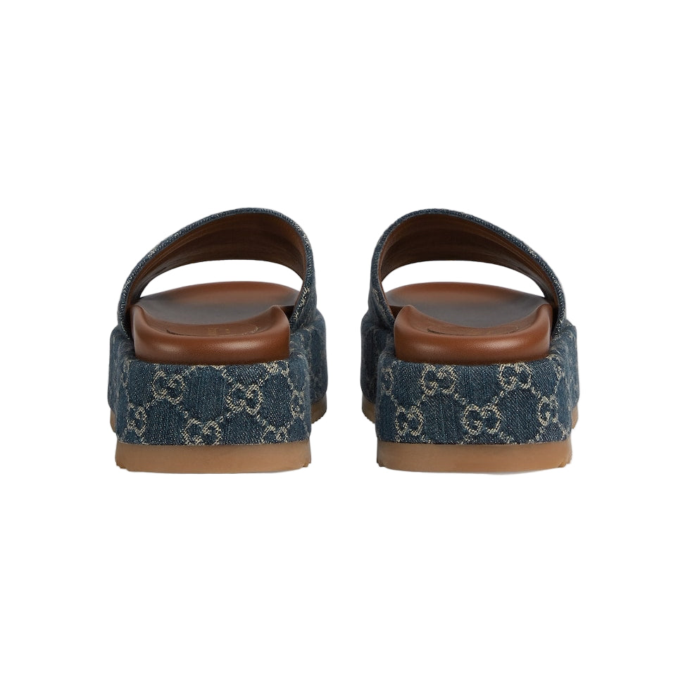 Pair of blue patterned sandals with brown soles on a light gray background