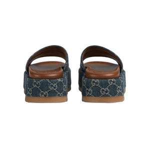 Pair of blue patterned sandals with brown soles on a light gray background