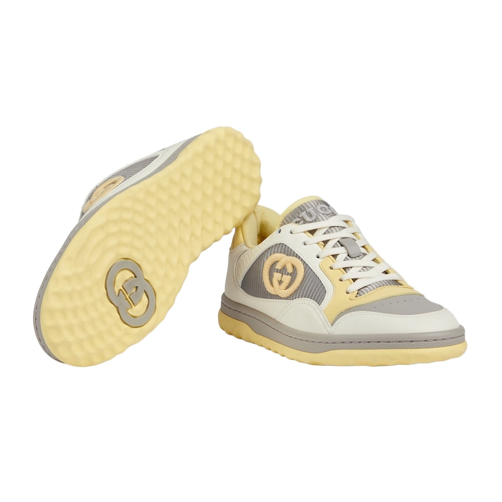 Yellow and gray sneakers with a brand logo on a light gray background