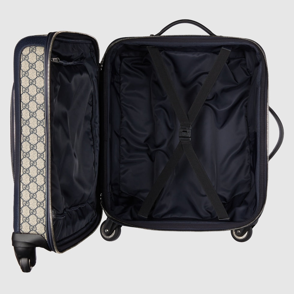 Open black suitcase with patterned interior on a light gray background
