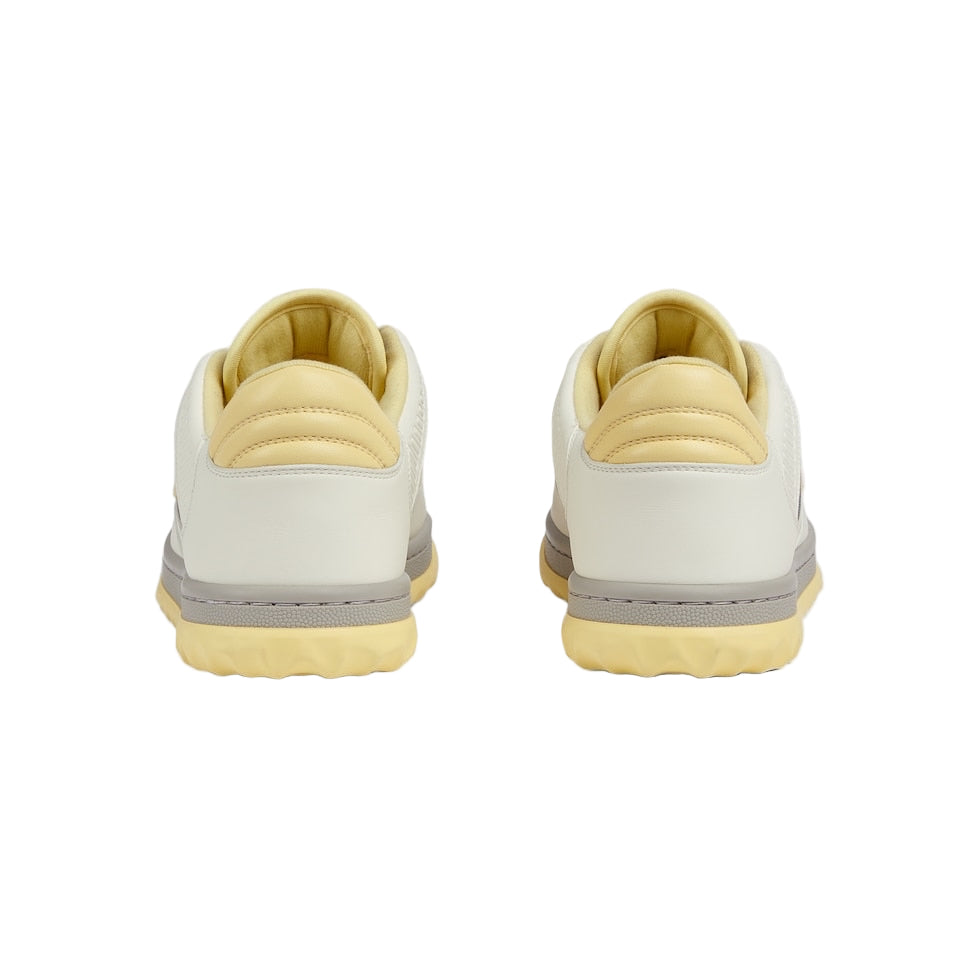 Pair of beige sneakers with gray accents on a light gray background