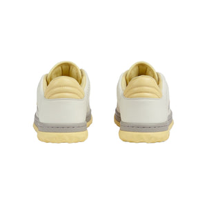 Pair of beige sneakers with gray accents on a light gray background
