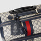 Designer luggage with visible Gucci logo and tag on a light gray background