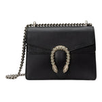 Black leather handbag with chain strap and decorative clasp on a white background