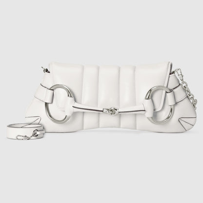 White quilted handbag with silver chain and clasp on a light gray background