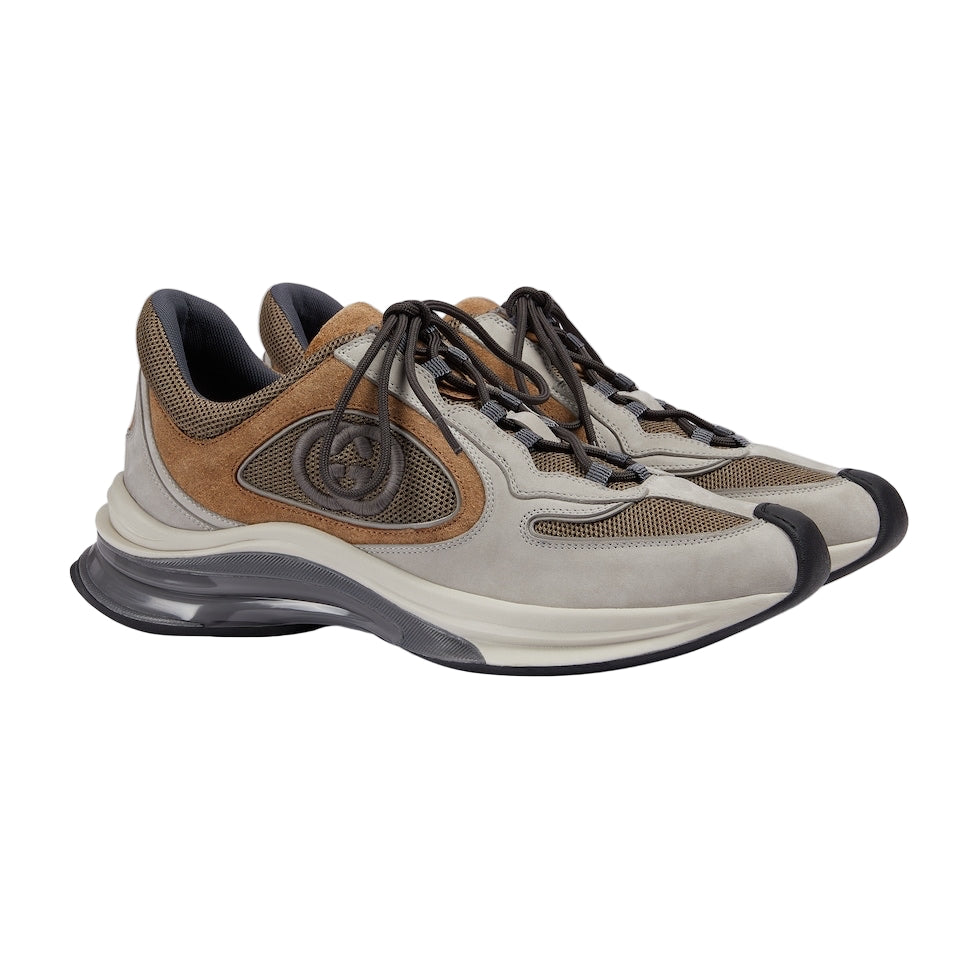 Pair of brown and beige sneakers on a light gray background