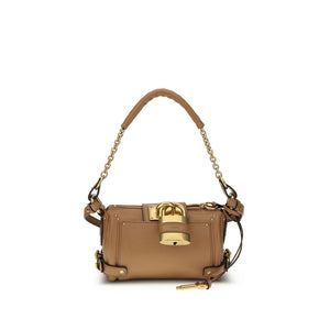 Brown handbag with gold accents on a white background