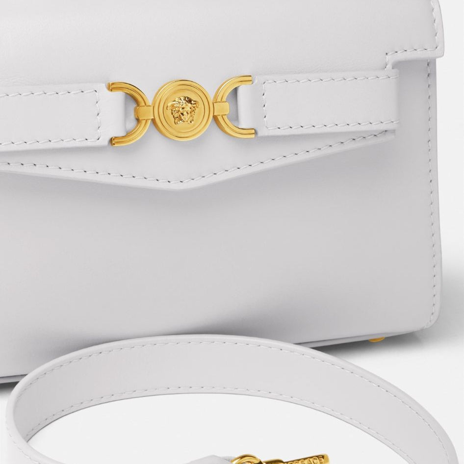 White handbag with gold accents on a white background