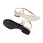 Pair of white sandals with thin straps on a light gray background