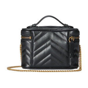 Black quilted Gucci handbag with gold chain on a light gray background