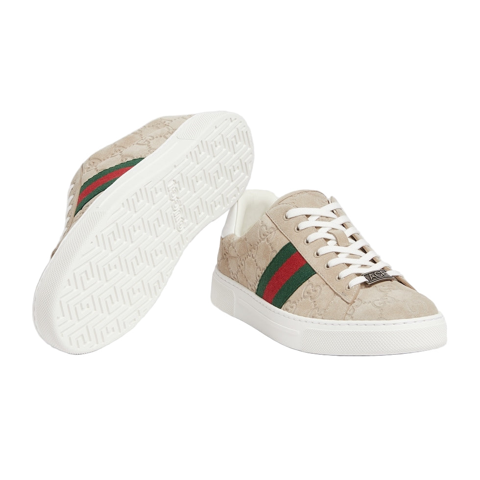 Beige sneakers with green and red stripes on a light gray background