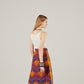 Woman wearing a colorful patterned skirt on a plain background
