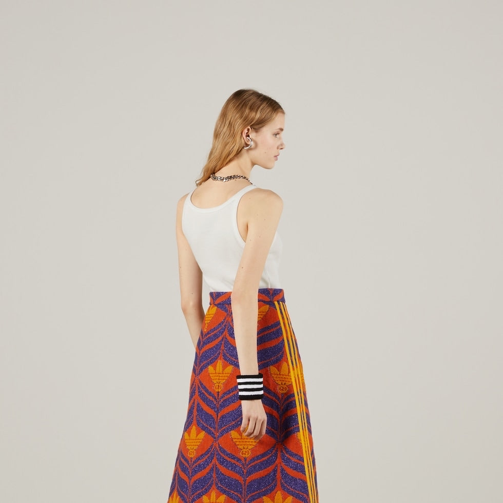 Woman wearing a colorful patterned skirt on a plain background
