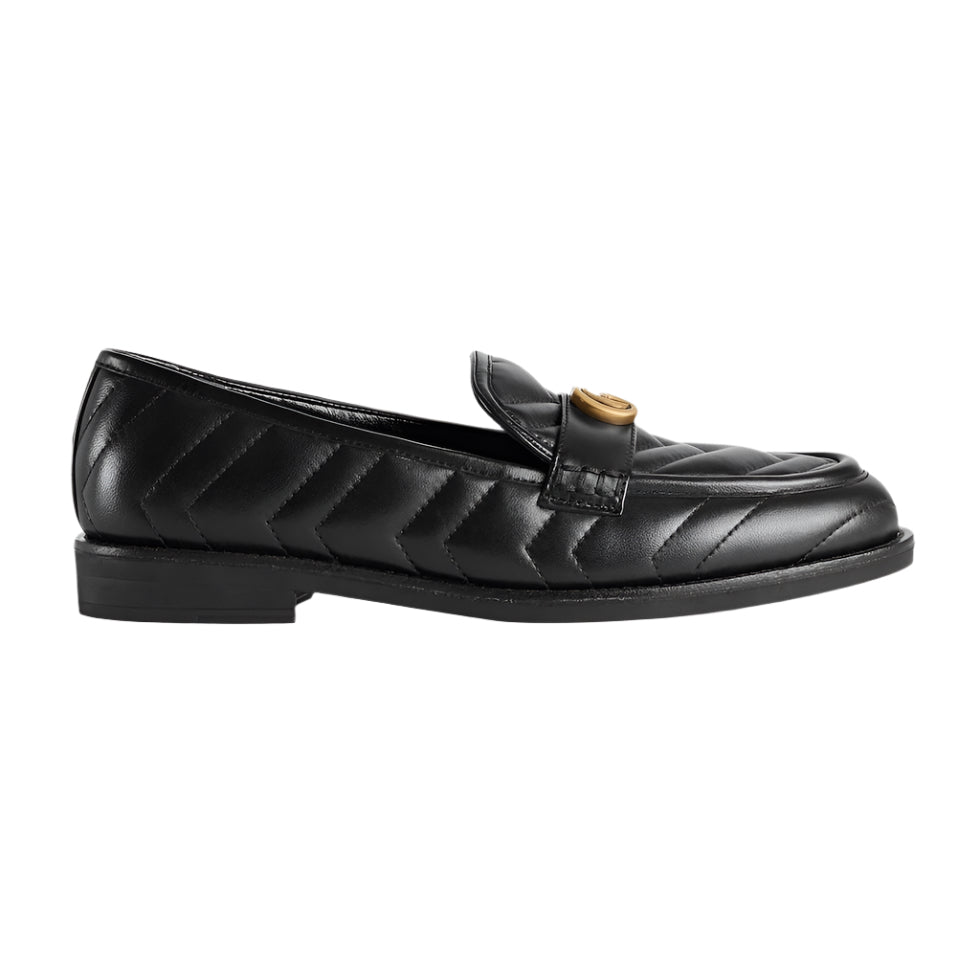 Black quilted loafer with gold buckle on a light gray background