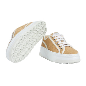 Tan sneakers with white soles on a light gray background