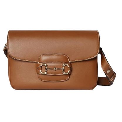 Brown leather luxury Gucci handbag with a gold buckle on a light gray background