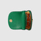 Green leather clutch with floral interior on a light gray background