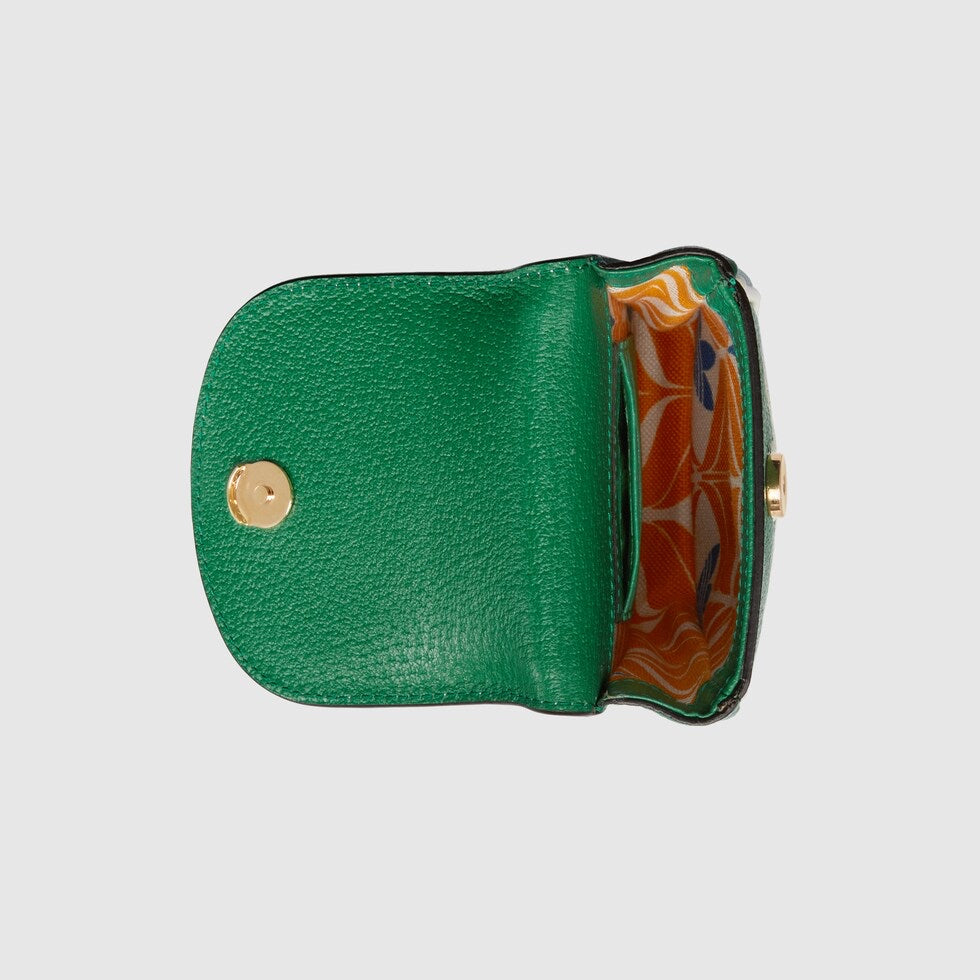 Green leather clutch with floral interior on a light gray background