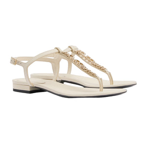 Pair of white sandals with gold chain detail on a light gray background