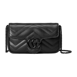 Black quilted handbag with chain strap on a light gray background