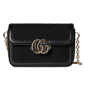 Black handbag with gold chain and logo on a light gray background