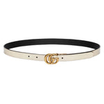 Black and white belt with a gold double G buckle on a light gray background