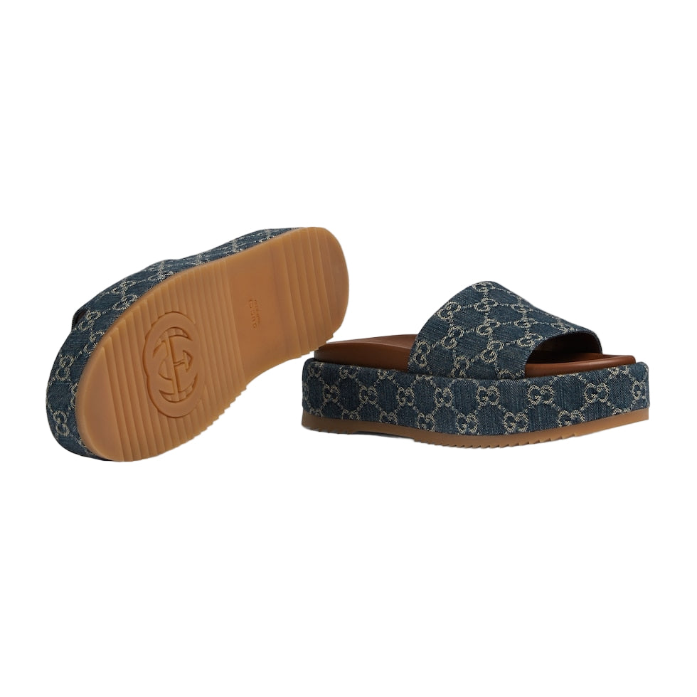 Blue patterned slide sandals with brown soles on a light gray background