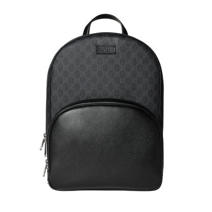 Black backpack with patterned top section on a light gray background