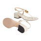 Beige sandals with gold accents on a light gray background