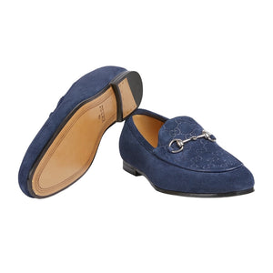 Blue loafers with a decorative buckle on a light gray background