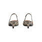 Pair of high-heeled shoes with decorative pattern on a light gray background