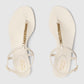 Pair of Gucci sandals with gold chain detail on a light gray background