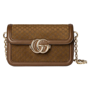 Brown handbag with gold chain and logo on a light gray background