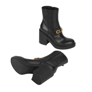 Black boots with gold logo on a light gray background