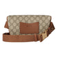 Gucci belt bag with patterned fabric and brown leather accents on a light gray background