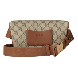 Gucci belt bag with patterned fabric and brown leather accents on a light gray background