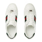 White sneakers with green and red accents on a light gray background