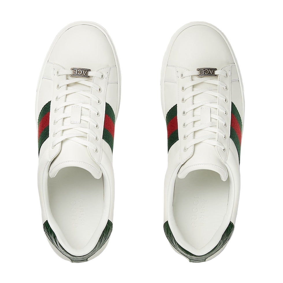 White sneakers with green and red accents on a light gray background