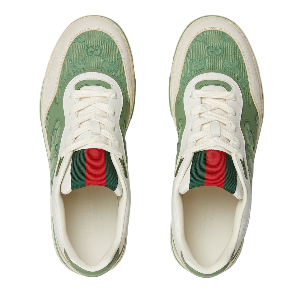 Green and white sneakers with red accents on a light gray background