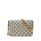 Designer handbag with gold chain strap on a light gray background