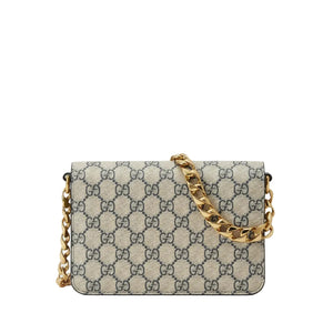 Designer handbag with gold chain strap on a light gray background