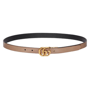 Two-toned belt with gold Gucci logo buckle on a light gray background