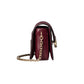 Burgundy handbag with gold chain on a light gray background