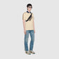 Person wearing a light yellow polo shirt with black accents and blue jeans on a white background