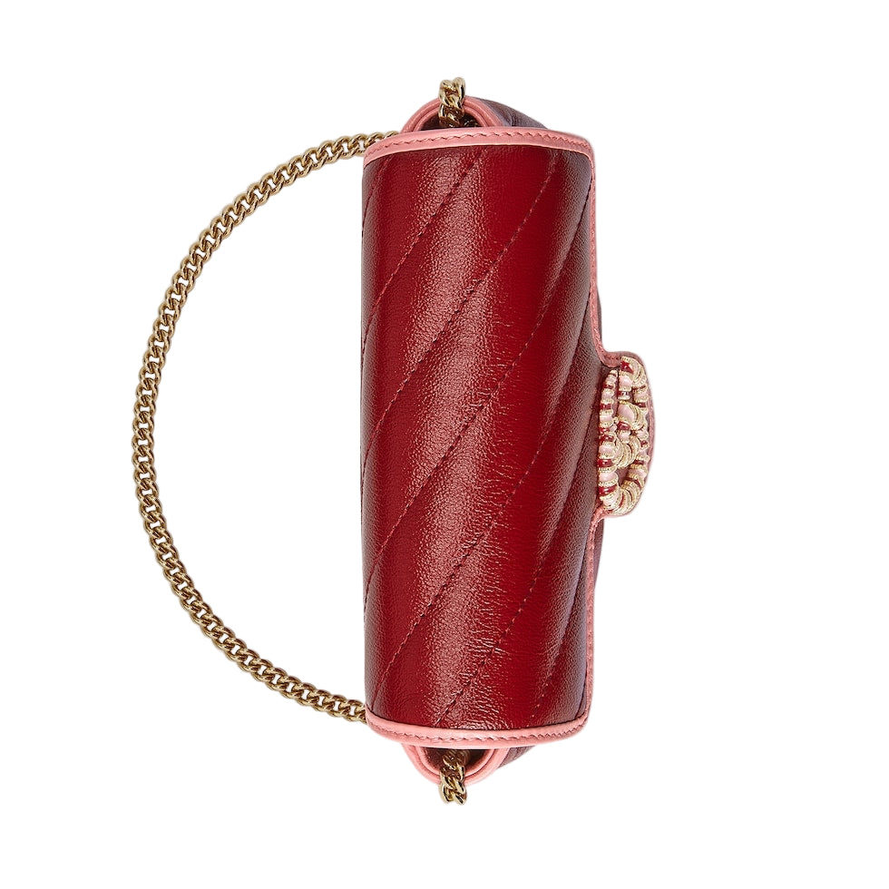 Red handbag with gold chain strap on a light gray background