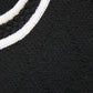 Close-up of a black sweater with white ribbed trim